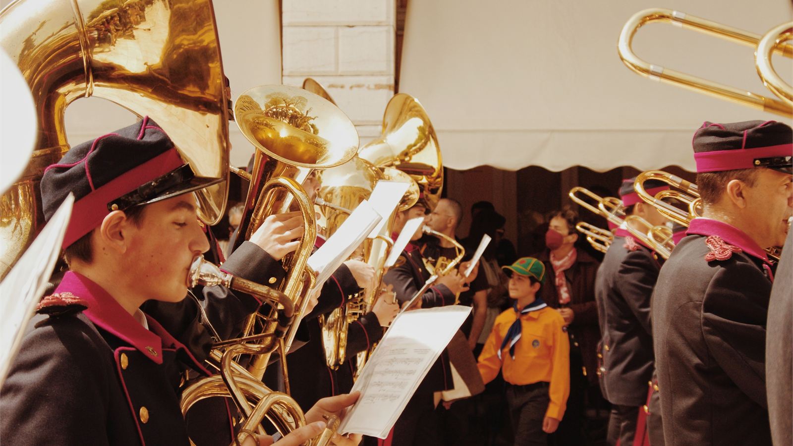 Leden van een muziekvereniging spelen samen tijdens een optocht.